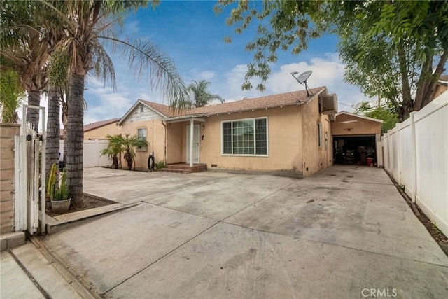 view of front of property with stucco siding, fence, and an attached garage