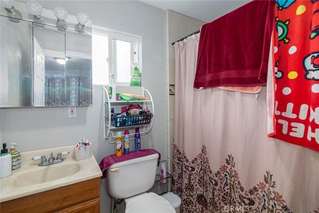 bathroom featuring toilet, vanity, and a shower with curtain