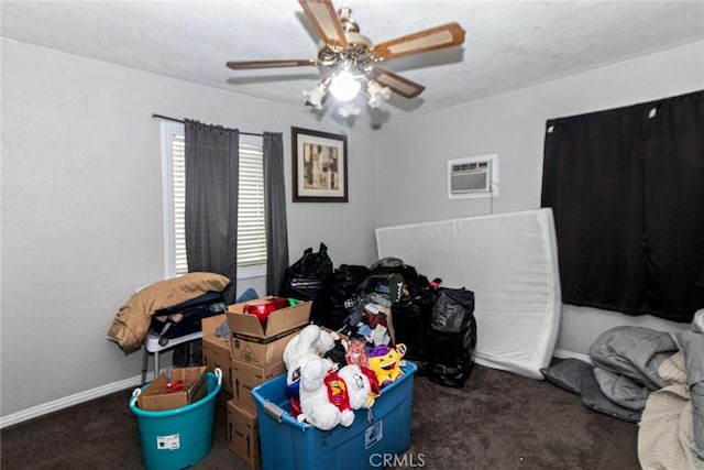 bedroom with carpet floors, an AC wall unit, a ceiling fan, and baseboards