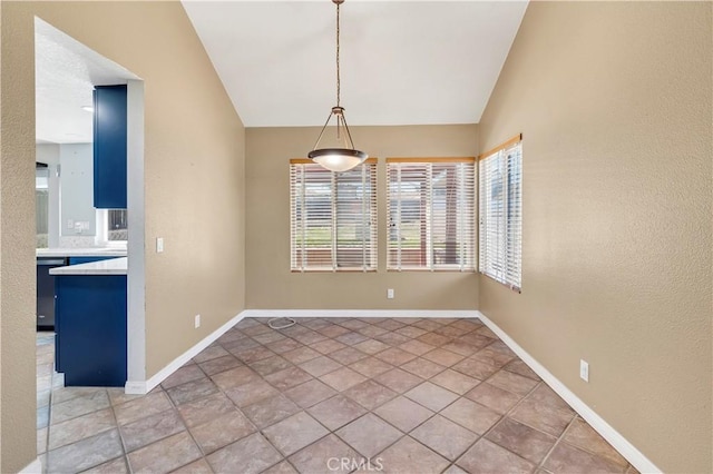 unfurnished dining area with baseboards and lofted ceiling