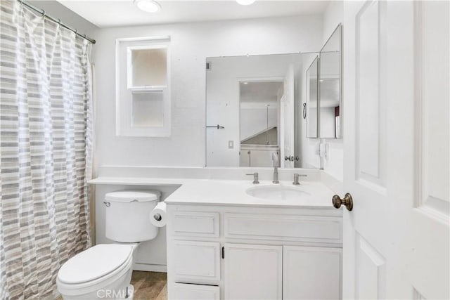 full bath featuring toilet, vanity, and a shower with shower curtain