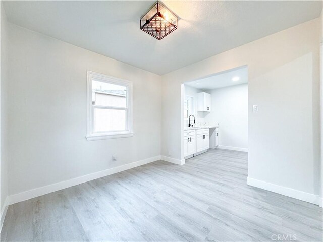 5557 Lemon Ave, Long Beach, CA 90805 - empty room featuring baseboards, light wood finished floors, and a sink