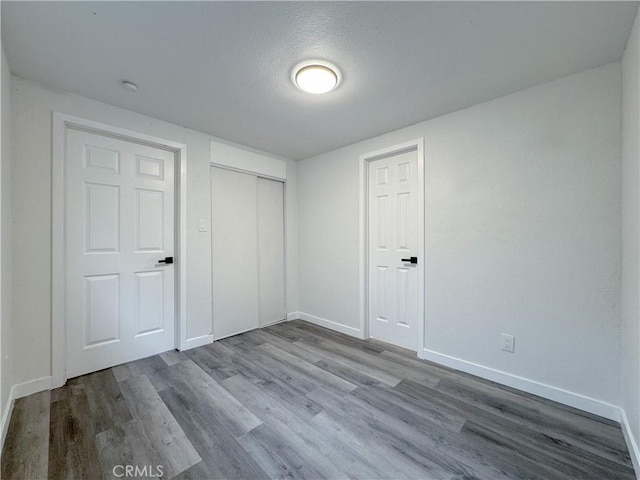 5557 Lemon Ave, Long Beach, CA 90805 - unfurnished bedroom with baseboards, wood finished floors, a closet, and a textured ceiling