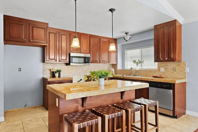 kitchen featuring stainless steel appliances, a sink, light countertops, decorative backsplash, and pendant lighting