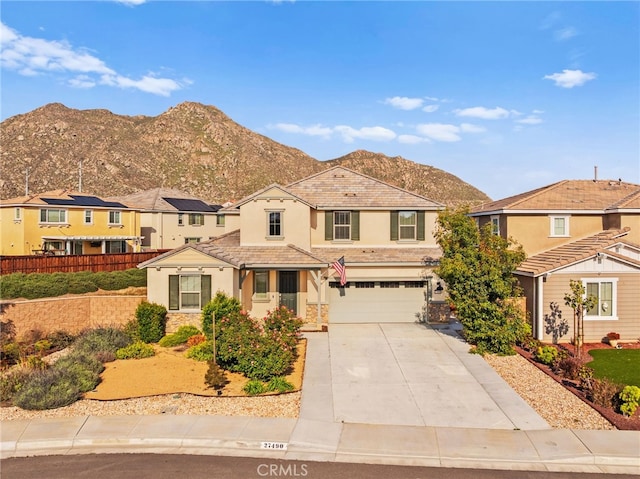 27490 Grand Teton Ct, Menifee, CA 92585 - traditional-style home with an attached garage, stucco siding, driveway, a mountain view, and stone siding