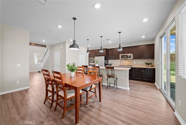 27490 Grand Teton Ct, Menifee, CA 92585 - dining room with light wood-type flooring, stairway, recessed lighting, and baseboards