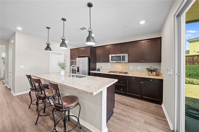 27490 Grand Teton Ct, Menifee, CA 92585 - kitchen with appliances with stainless steel finishes, a sink, light wood-type flooring, dark brown cabinets, and recessed lighting