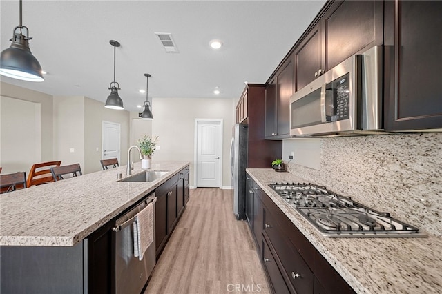 27490 Grand Teton Ct, Menifee, CA 92585 - kitchen with appliances with stainless steel finishes, a sink, a kitchen island with sink, light wood-type flooring, and recessed lighting