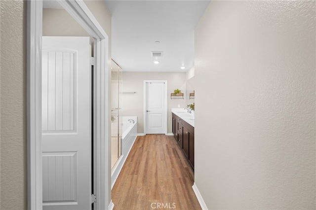 27490 Grand Teton Ct, Menifee, CA 92585 - full bathroom featuring a garden tub, wood finished floors, vanity, baseboards, and recessed lighting