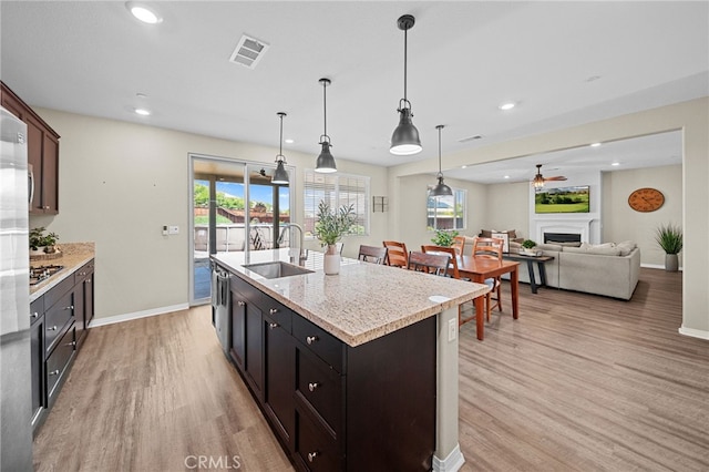 27490 Grand Teton Ct, Menifee, CA 92585 - kitchen with a sink, baseboards, light wood-style floors, a fireplace, and a ceiling fan