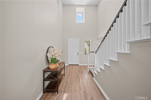 27490 Grand Teton Ct, Menifee, CA 92585 - entryway featuring wood finished floors, healthy amount of natural light, baseboards, stairway, and a towering ceiling