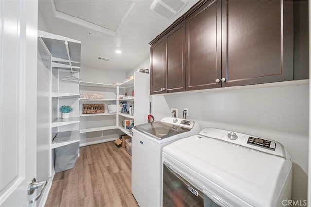 27490 Grand Teton Ct, Menifee, CA 92585 - washroom with cabinet space, separate washer and dryer, and light wood-style flooring
