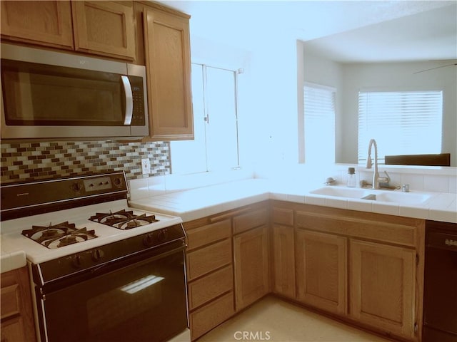 1806 Rory Ln Unit 9, Simi Valley, CA 93063 - kitchen featuring white range with gas cooktop, stainless steel microwave, black dishwasher, tile counters, and decorative backsplash