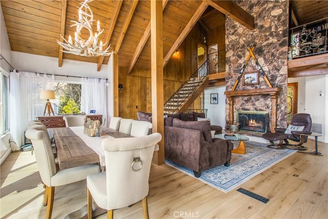 28834 Zion Dr, Lake Arrowhead, CA 92352 - dining room featuring wooden ceiling, a chandelier, beamed ceiling, wood finished floors, and stairs