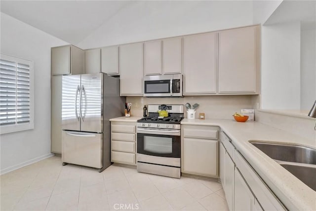 7402 Yellowtail Dr Unit 204, Huntington Beach, CA 92648 - kitchen featuring appliances with stainless steel finishes, light countertops, lofted ceiling, and light tile patterned flooring