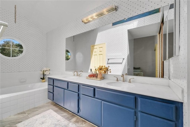 7402 Yellowtail Dr Unit 204, Huntington Beach, CA 92648 - ensuite bathroom with wallpapered walls, double vanity, a bath, and lofted ceiling