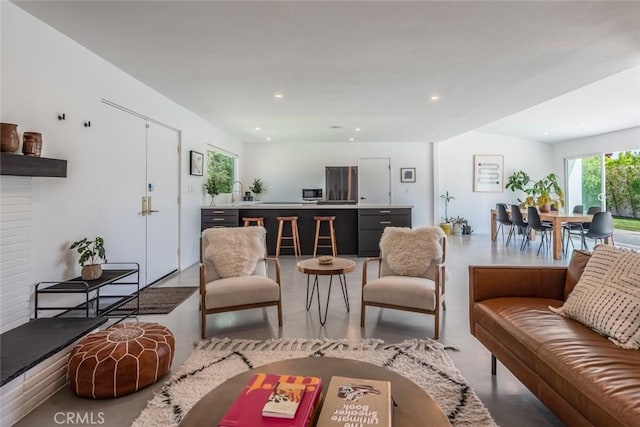living room with finished concrete flooring and recessed lighting