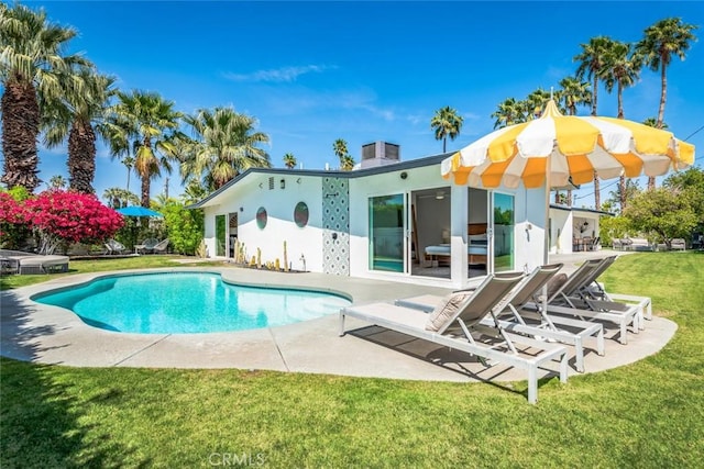 swimming pool featuring a patio area and a lawn