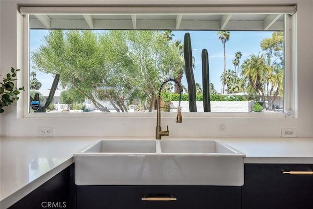 kitchen featuring a sink, light countertops, and plenty of natural light