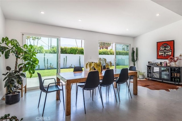 dining space featuring concrete floors, healthy amount of natural light, and recessed lighting
