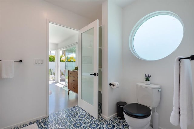 bathroom featuring tile patterned floors, toilet, and baseboards