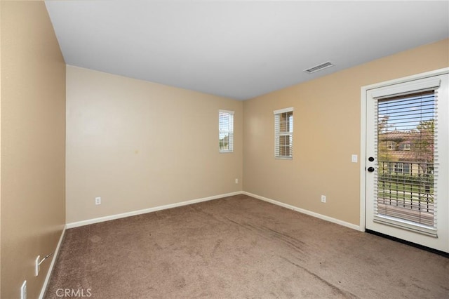carpeted empty room with healthy amount of natural light and baseboards