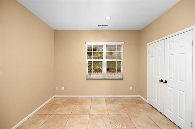 unfurnished bedroom with light tile patterned floors, baseboards, recessed lighting, and a closet