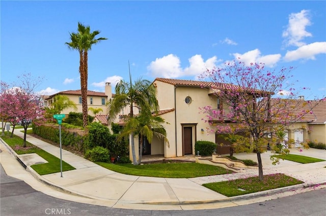 mediterranean / spanish-style house featuring stucco siding and a tiled roof