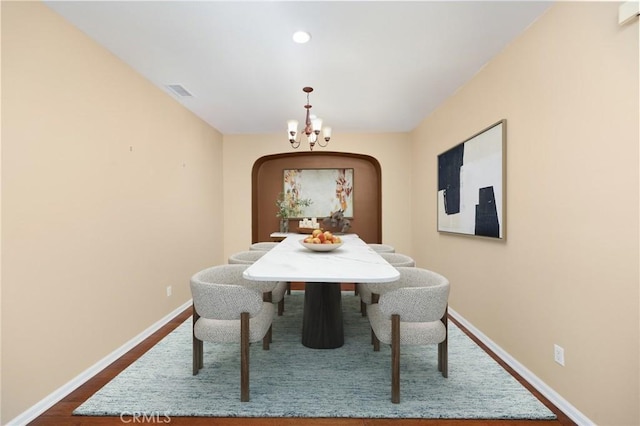 dining room with arched walkways, a chandelier, dark wood-style flooring, baseboards, and recessed lighting