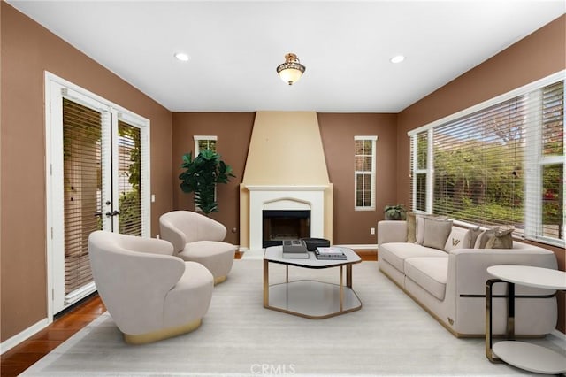 living room with wood finished floors, recessed lighting, a fireplace, and baseboards