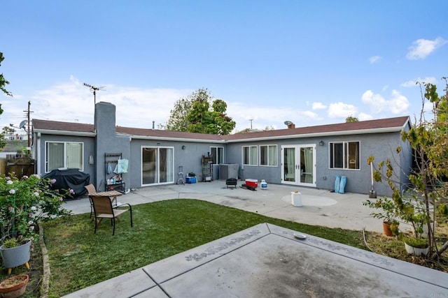 2045 Cardinal Dr, San Diego, CA 92123 - rear view of house with french doors, a patio area, a yard, stucco siding, and a chimney
