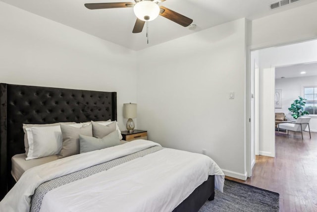 bedroom with wood finished floors, baseboards, and ceiling fan
