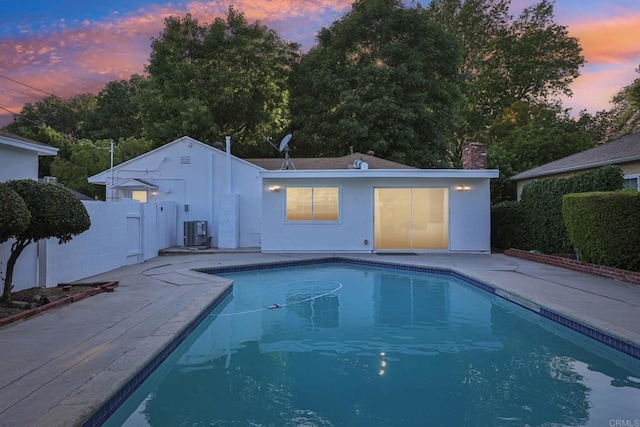 back of property with central AC unit, a patio, a chimney, stucco siding, and fence