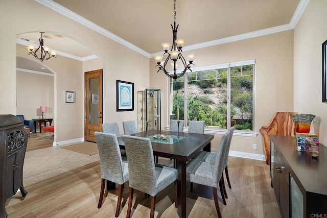 2021 Willow Glen Rd, Fallbrook, CA 92028 - dining area with a chandelier, arched walkways, baseboards, light wood finished floors, and ornamental molding