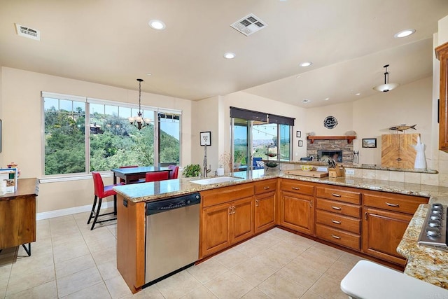 2021 Willow Glen Rd, Fallbrook, CA 92028 - kitchen featuring appliances with stainless steel finishes, brown cabinets, light tile patterned floors, light stone countertops, and plenty of natural light