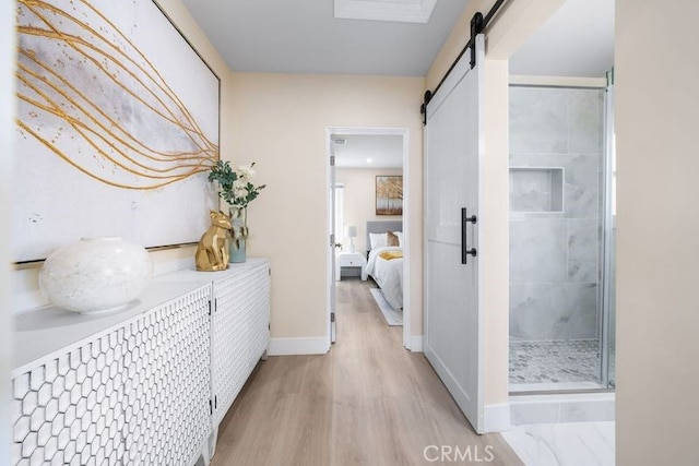 821 S 10th St, Montebello, CA 90640 - hall featuring a barn door, light wood finished floors, and baseboards