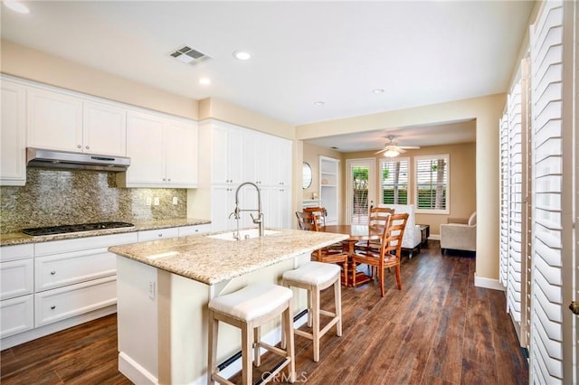 7 Honeydew, Irvine, CA 92603 - kitchen with under cabinet range hood, gas stovetop, a sink, light stone counters, and dark wood-style floors