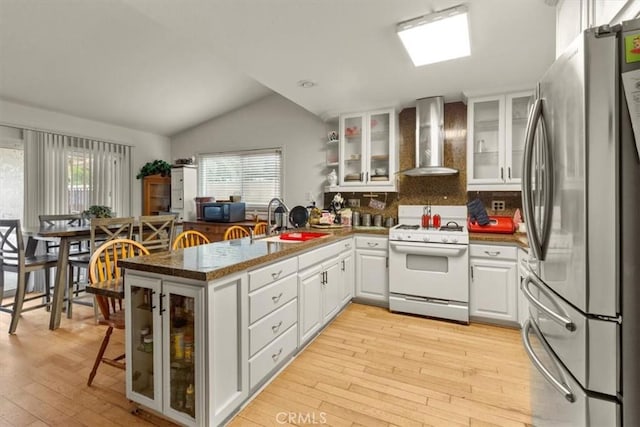 2522 S Calaveras Pl, Ontario, CA 91761 - kitchen featuring wall chimney exhaust hood, freestanding refrigerator, gas range gas stove, a sink, and vaulted ceiling