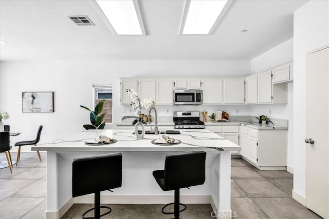 3773 Mission, Peak, Palm Springs, CA 92262 - kitchen with stainless steel appliances, a sink, white cabinetry, a kitchen island with sink, and a kitchen bar