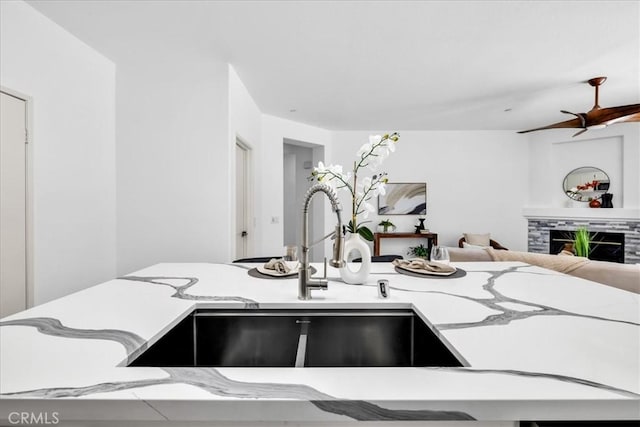 3773 Mission, Peak, Palm Springs, CA 92262 - kitchen with a sink, a fireplace, a ceiling fan, open floor plan, and light stone counters