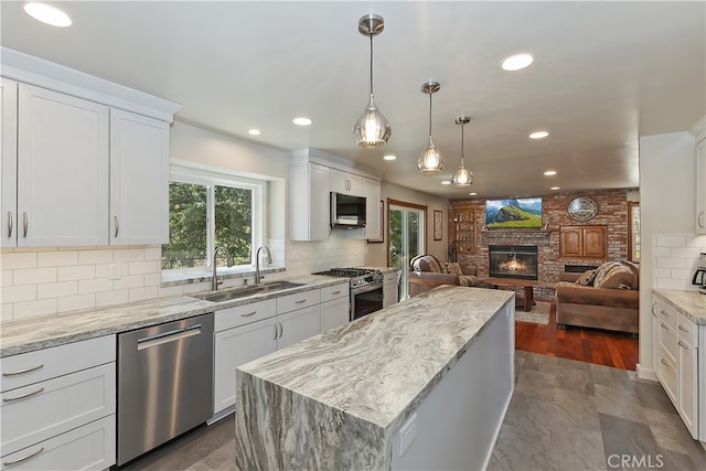 27513 St Bernard Ln, Lake Arrowhead, CA 92352 - kitchen with appliances with stainless steel finishes, a sink, a brick fireplace, recessed lighting, and a center island