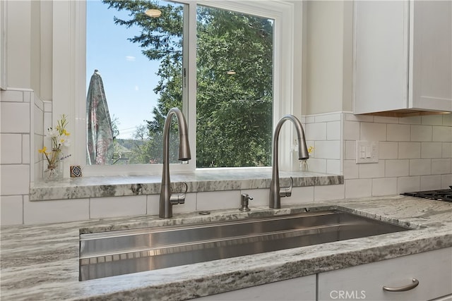 27513 St Bernard Ln, Lake Arrowhead, CA 92352 - kitchen view of a sink, white cabinetry, tasteful backsplash, and light stone countertops