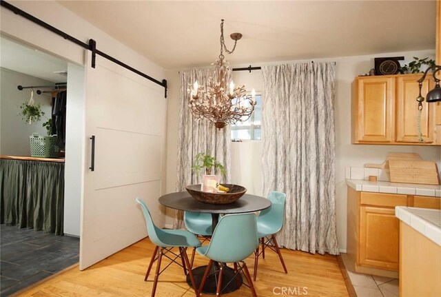 10233 Marcus Ave, Tujunga, CA 91042 - dining space with a barn door, a chandelier, and light wood-style floors