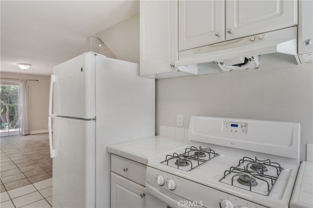2707 S El Camino Real, San Clemente, CA 92672 - kitchen featuring white appliances, under cabinet range hood, tile counters, light tile patterned floors, and white cabinetry