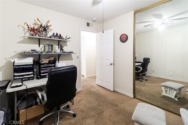 home office with a textured ceiling, carpet flooring, ceiling fan, and baseboards