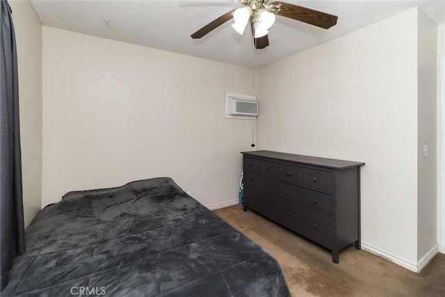 carpeted bedroom featuring a wall mounted air conditioner, baseboards, and a ceiling fan
