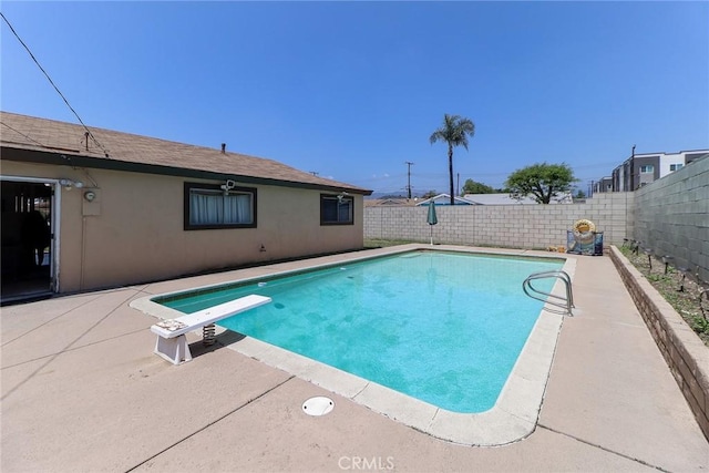 view of pool featuring a fenced backyard, a patio, and a diving board
