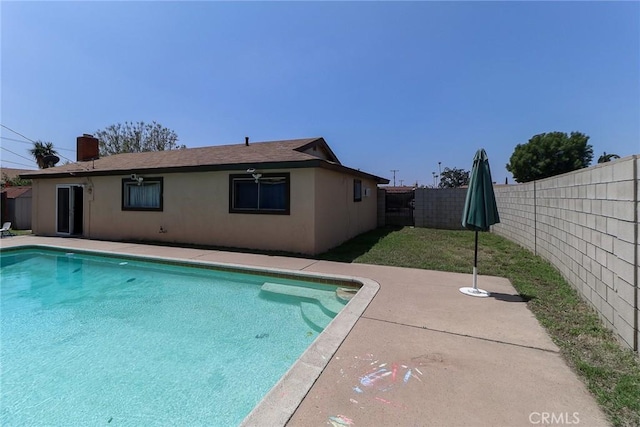 view of swimming pool featuring a fenced backyard and a patio