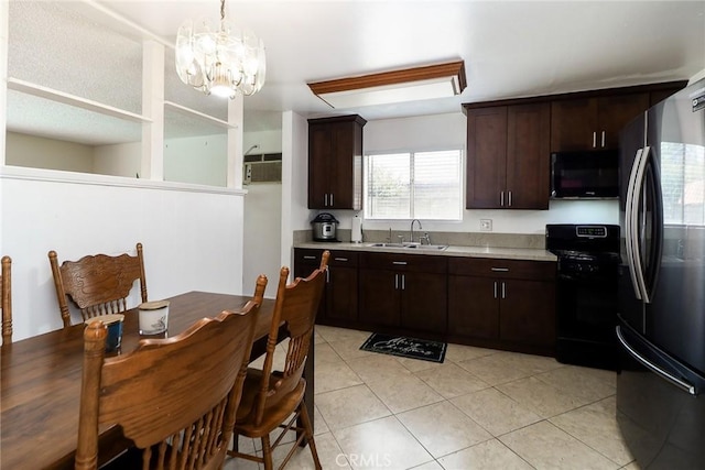 kitchen featuring black appliances, a chandelier, light countertops, and a sink