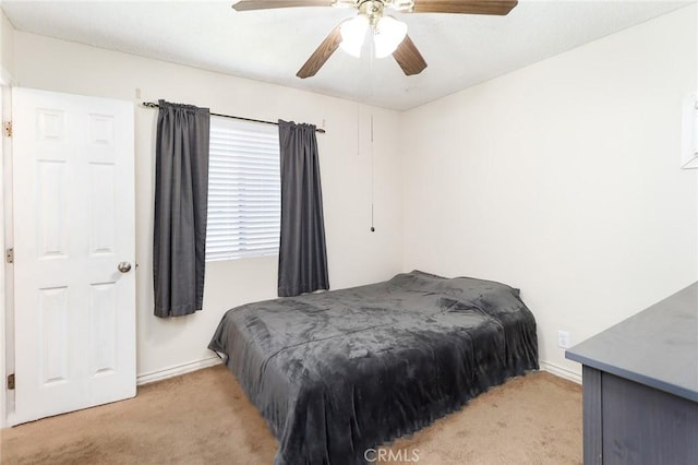 bedroom featuring light carpet, baseboards, and ceiling fan